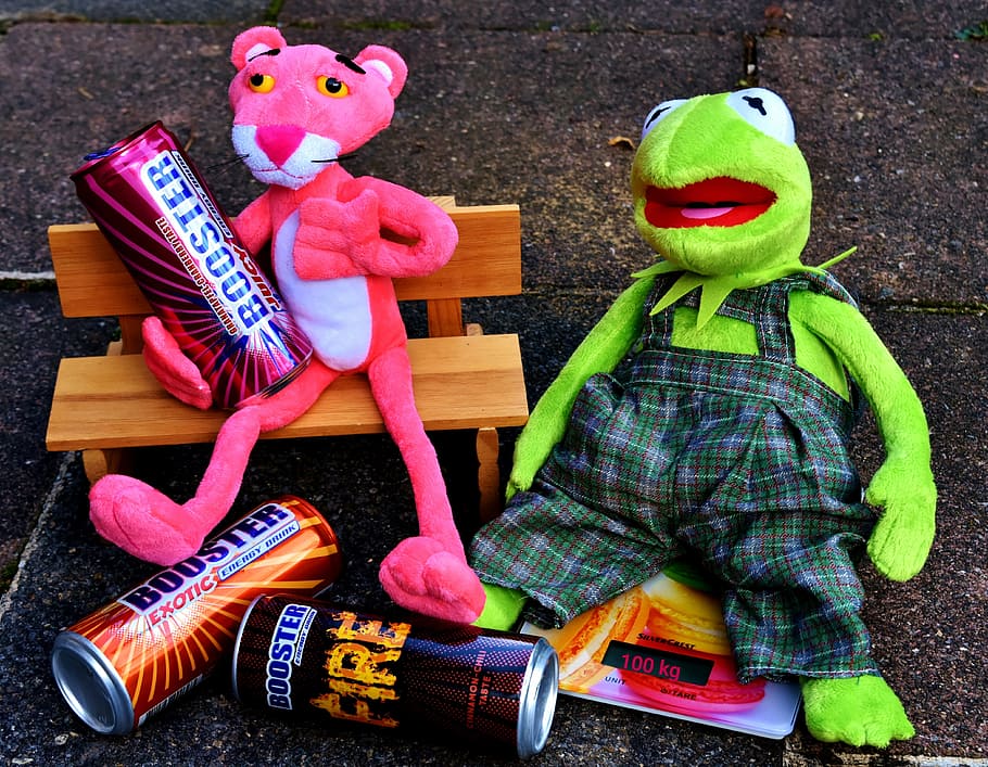 Pink Panther and Kermitt the Frog plush toys on concrete surface