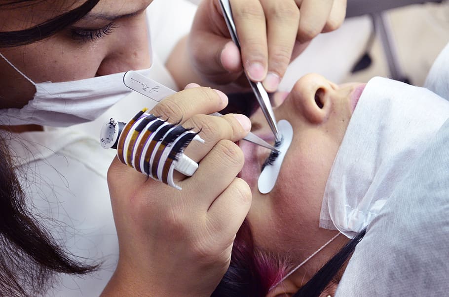 close-up photo of doctor operating person's eyelash, hair removal