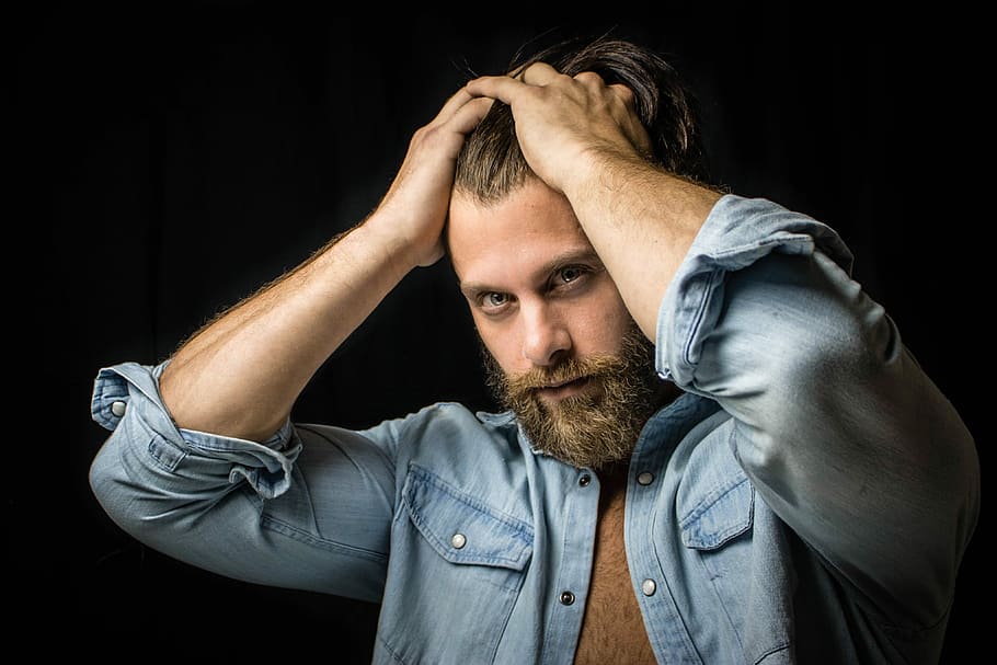 man in black background, man holding his head, portrait, beard HD wallpaper