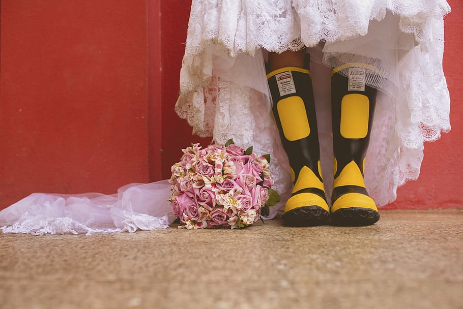 person wearing black-and-yellow rain boots beside flower bouquet, HD wallpaper