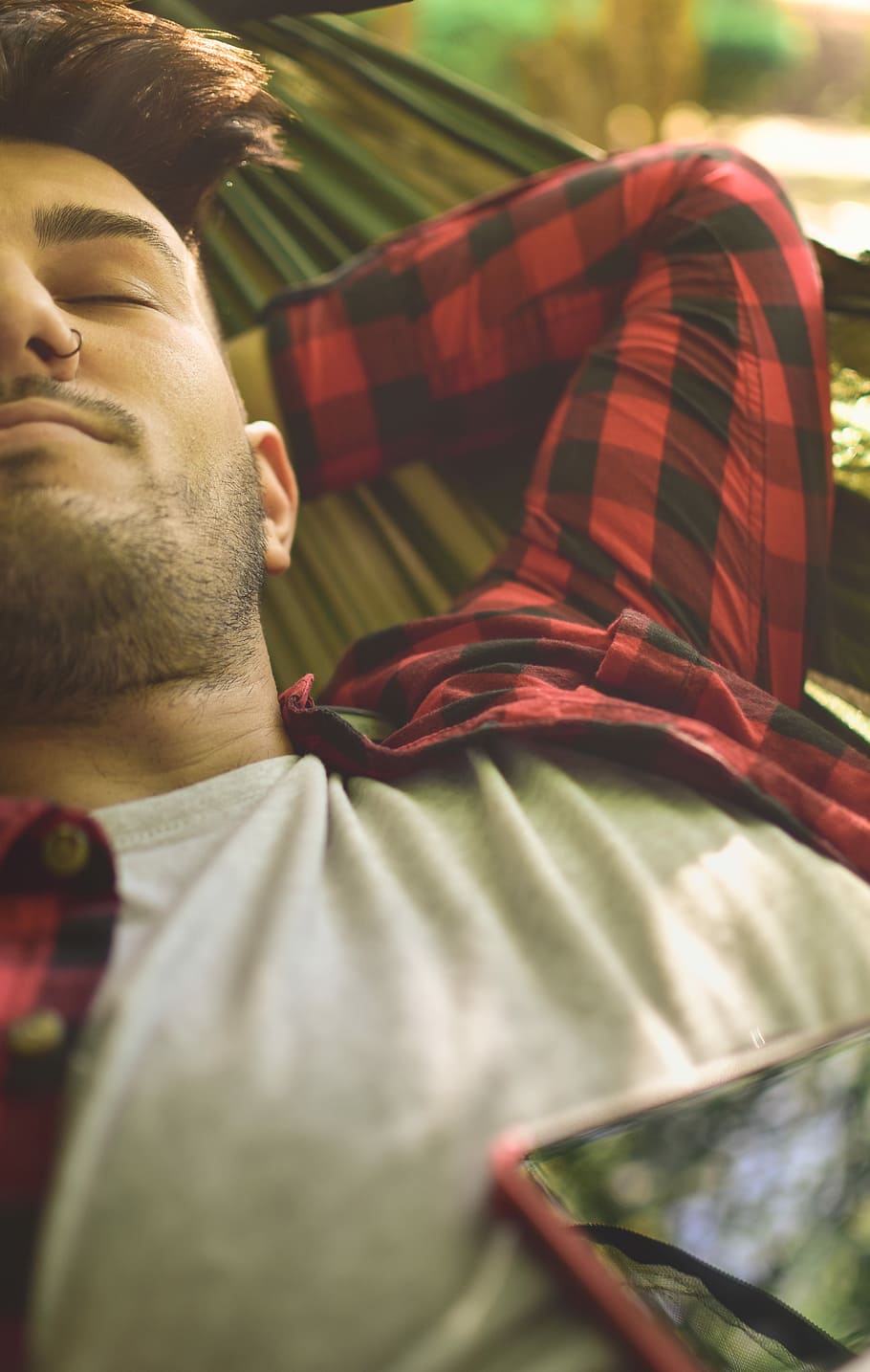 close photography of man lying on green hammock, man wearing red and black plaid dress shrit HD wallpaper