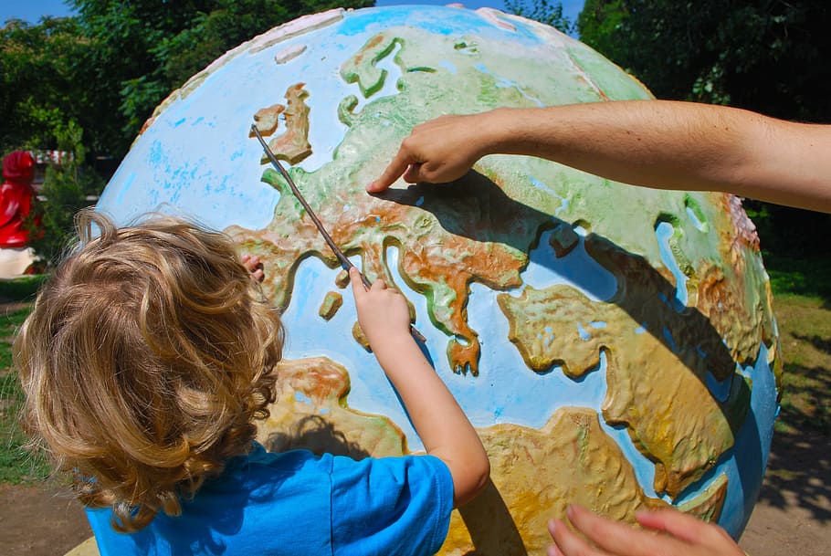 boy wearing blue t-shirt learning globe during daytime, geography HD wallpaper