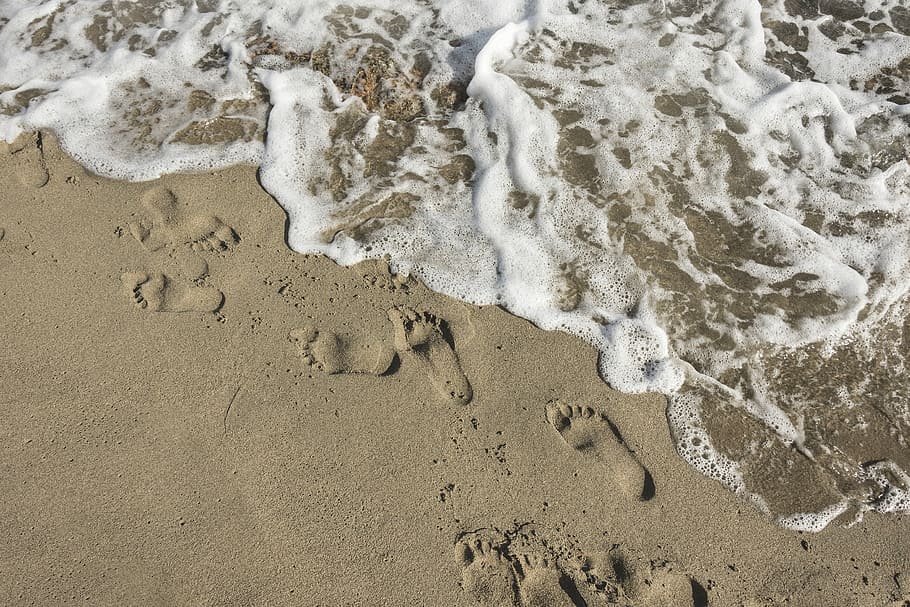 aerial photo of seashore, footprints on the sands near body of water HD wallpaper