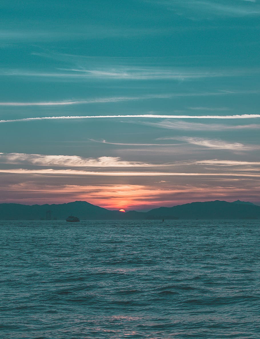 sunset over the mountain, boat far away from island during golden hour HD wallpaper