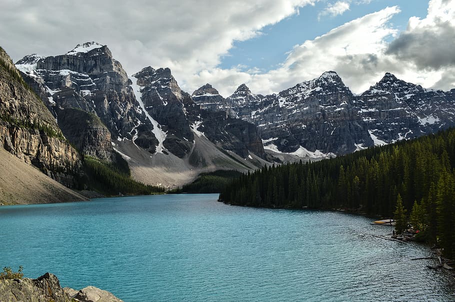 body of water in between snow-capped mountain under white and blue sky, body of water near mountains HD wallpaper