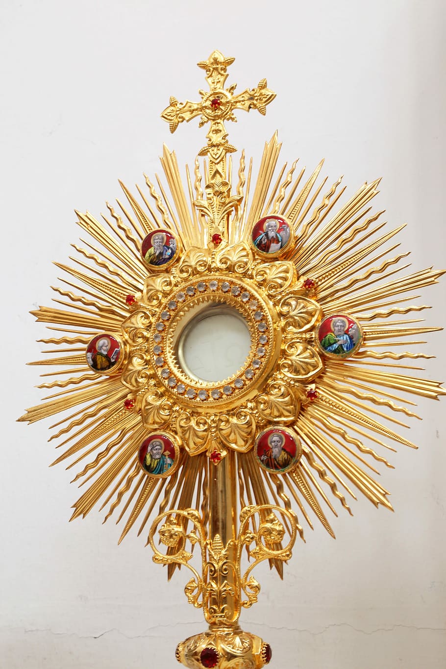 gold-colored, red, and white accessory, sun, burst, cross, accent