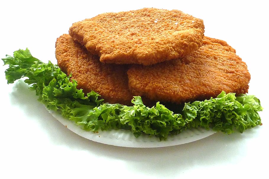 deep fried dish with vegetables on round white plate, chicken cutlet