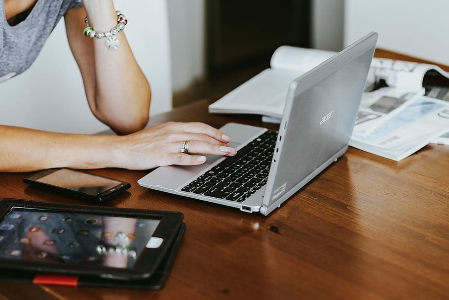 Silver laptop with various items on a table, magazines, computer HD wallpaper