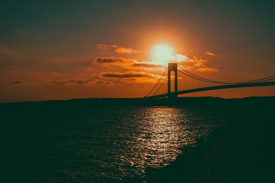 suspension bridge over body of water during golden hour, sunset HD wallpaper