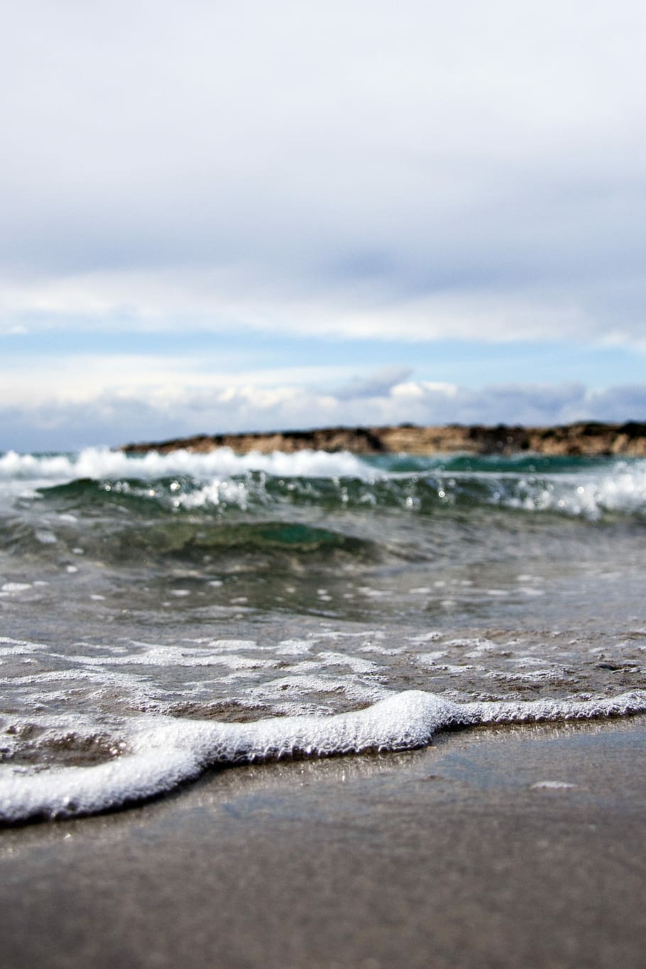 waves under white cloudy sky at daytime, sea shore during daytime under grey clouds HD wallpaper