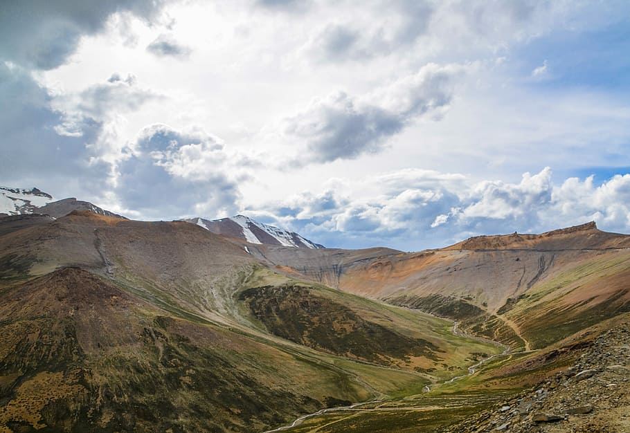 aerial photography of mountains under gray clouds and blue sky HD wallpaper
