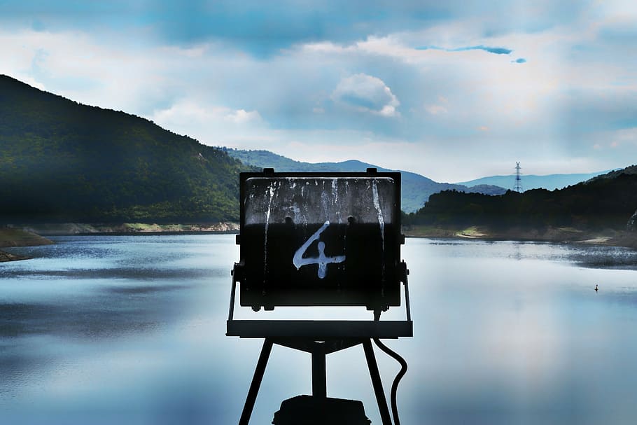 A sign marked with the number four over a lake, macro photography of black metal frame facing body of water HD wallpaper