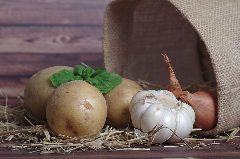 three potatoes, bulb of garlic, and two onions, peel potatoes