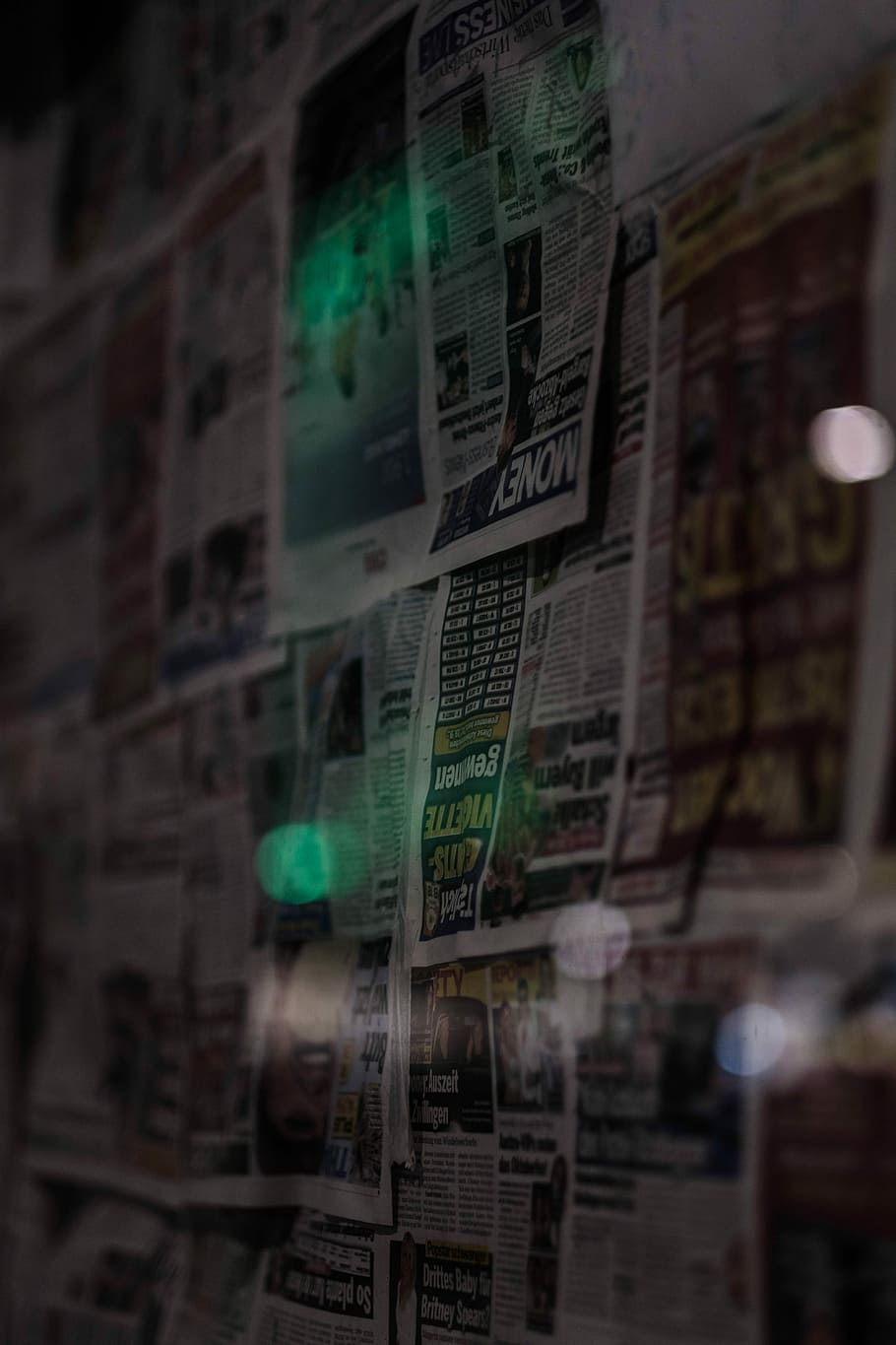 news paper article, newspaper sheets on wall, light, moody, dark