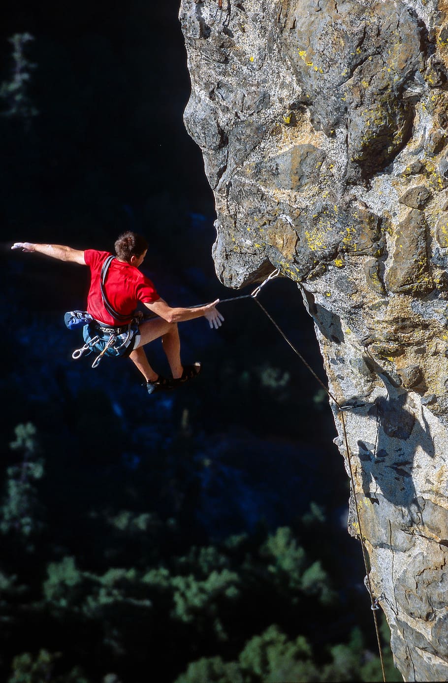 person rock climbing, man jumping at cliff with rope at daytime HD wallpaper