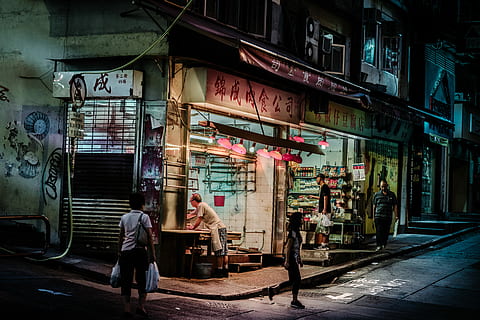When the night falls in Hong Kong, woman carrying two plastic bags HD wallpaper
