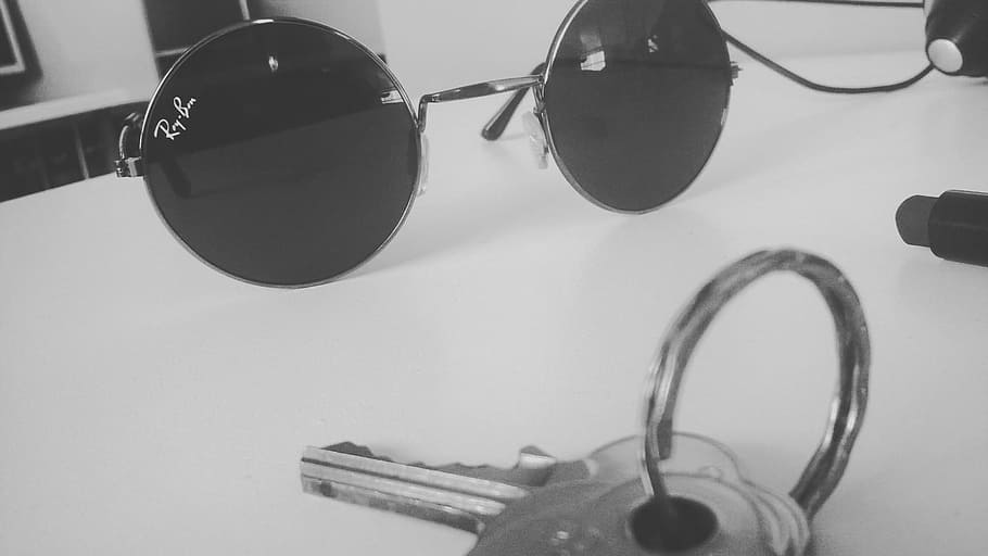 There are two glasses on the table. Black and White Sunglasses aesthetic.