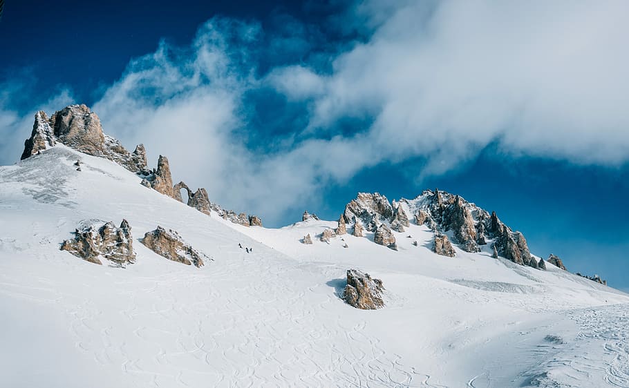 snow-covered rock mountain under clods, aerial photograph of mountain covered by snow at daytime HD wallpaper