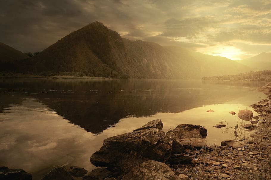 photo of calm water of lake near mountain during golden hour HD wallpaper