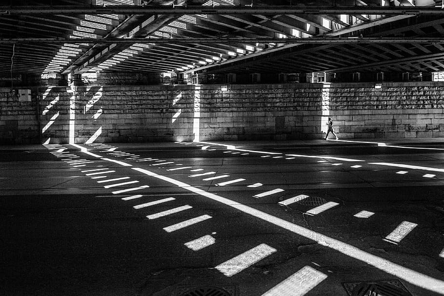 grayscale photography of man walking on road, gray concrete pavement HD wallpaper