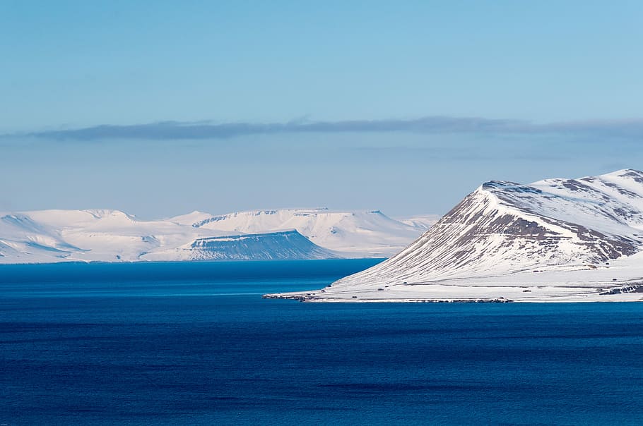 photo of mountains filled with snow near body of water, Svalbard