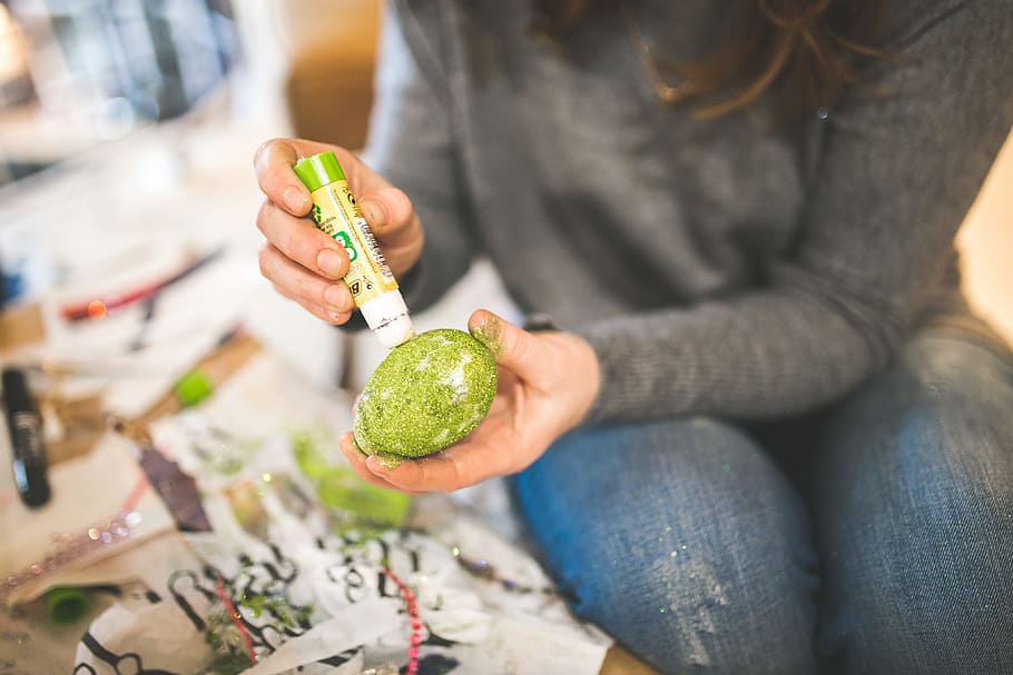 photo of woman in gray long sleeve top and blue jeans holding green coloring pen and egg HD wallpaper