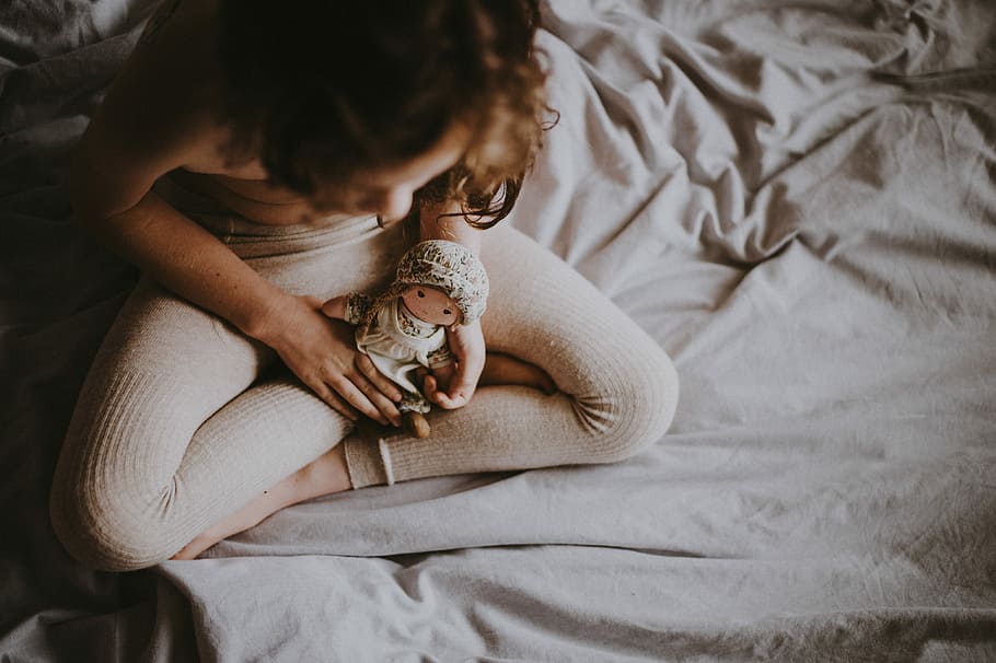 Child and doll, woman holding doll on bed, sheets, tights, furniture HD wallpaper