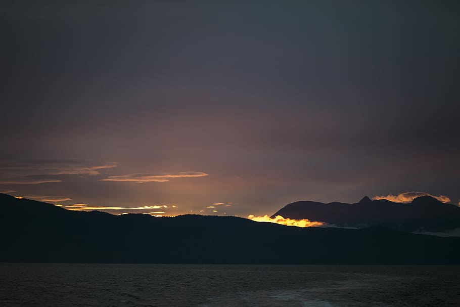 sunset over the horizon, silhouette photography of mountains HD wallpaper