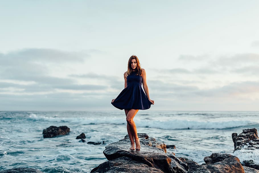 woman in black dress shirt on sea stone formation during daytime, HD wallpaper