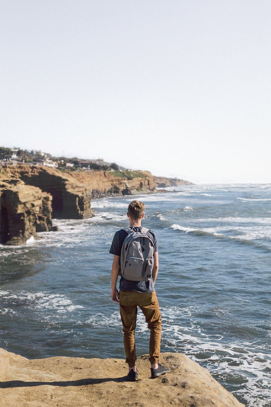man standing on brown cliff, nature, water, edge, waves, people HD wallpaper