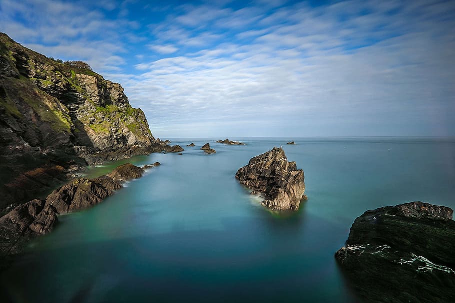 photo of grey rock formations on water during daytime, coast HD wallpaper