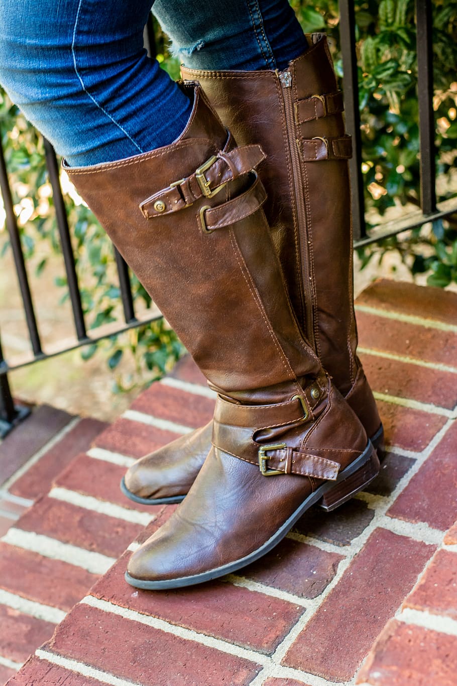 person wearing pair of brown leather round-toe stockman heeled knee-high boots