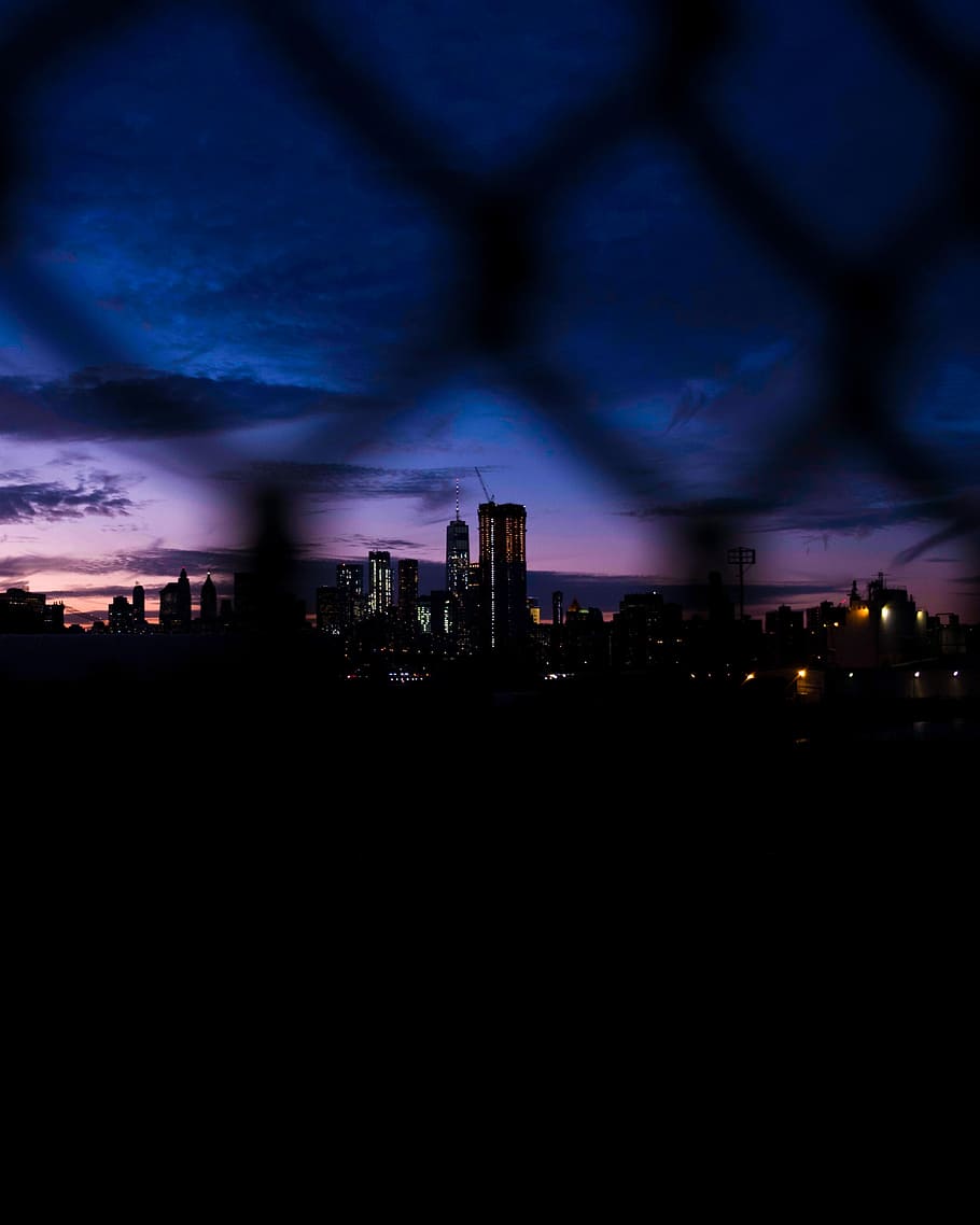 gray chain fence displaying cityscape, silhouette of buildings during night HD wallpaper