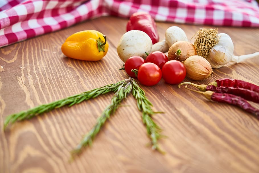 assorted spices on beige wooden table, vegetables, pepper, mushroom