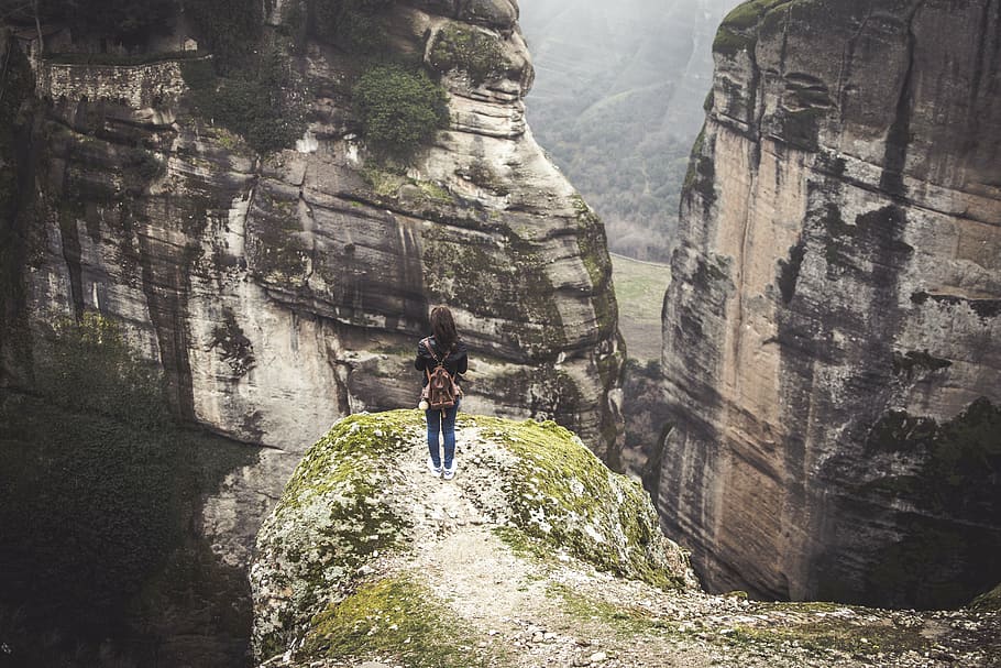 woman standing in front of rock formations during daytime, mountain HD wallpaper