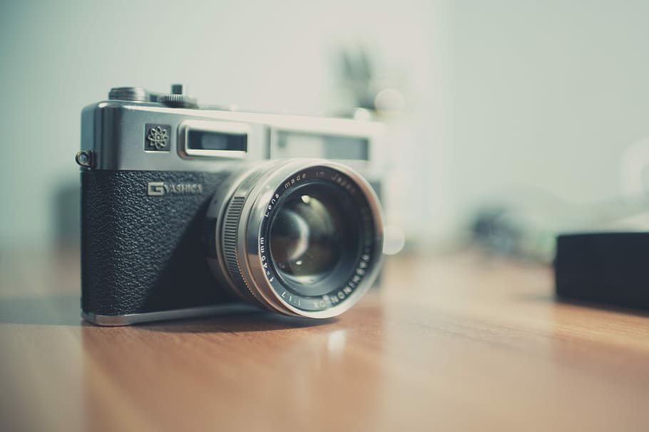 black and gray point-and-shoot camera, gray and black DSLR camera on table HD wallpaper