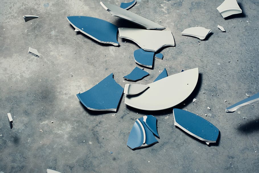 top view photography of broken ceramic plate, broken blue and white ceramic plate