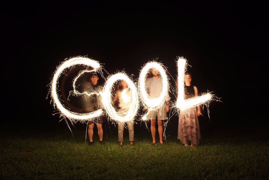 four people holding fireworks and forming cool word, four person with firecrackers