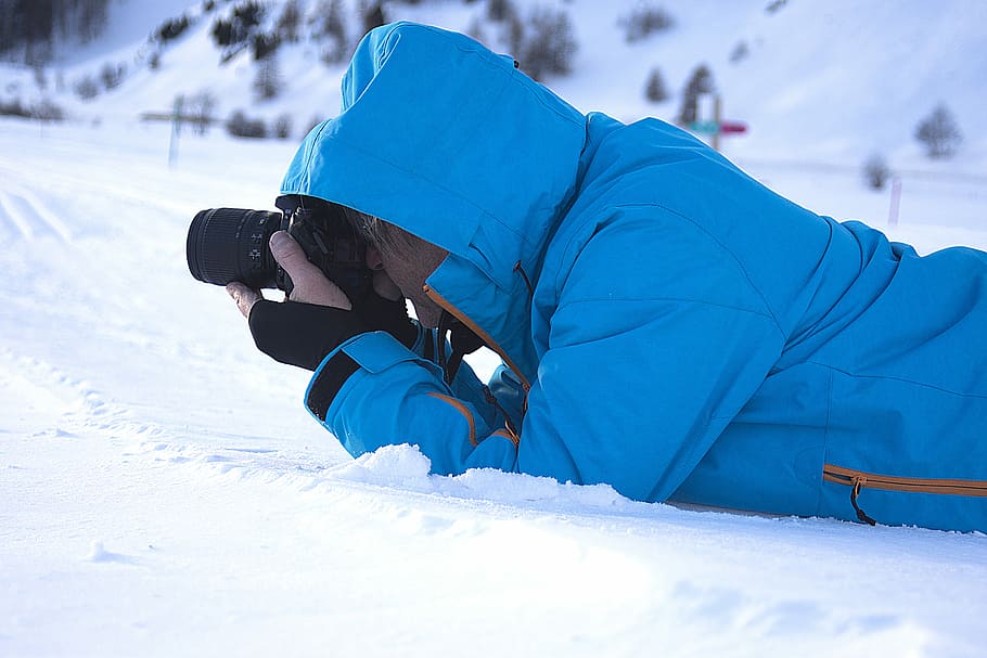 man taking photo, man lying on snowfield taking picture, blue jacket HD wallpaper