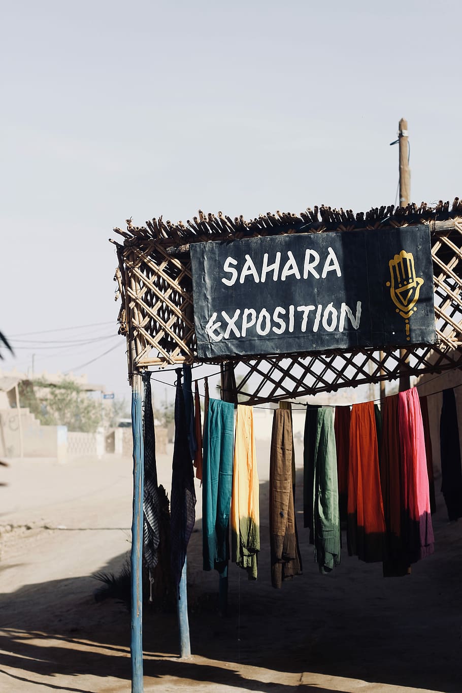sahara exposition signage near assorted-color apparel on clothesline during daytime, assorted-color textiles hanging on clothesline