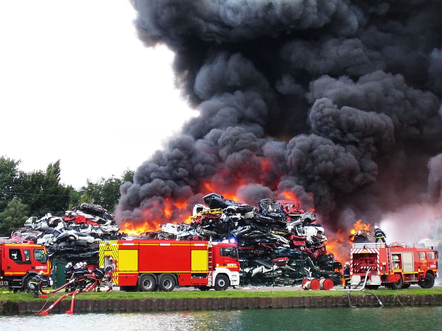 photo of burned cars surrounded by firetrucks, smoke, brand, vehicles