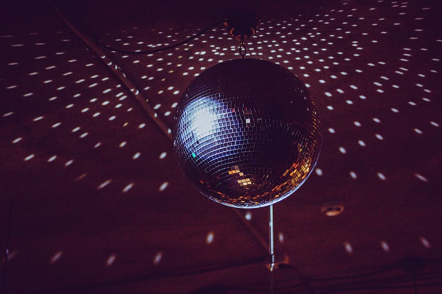 silver disco ball, black and brown disco ball turned on inside room