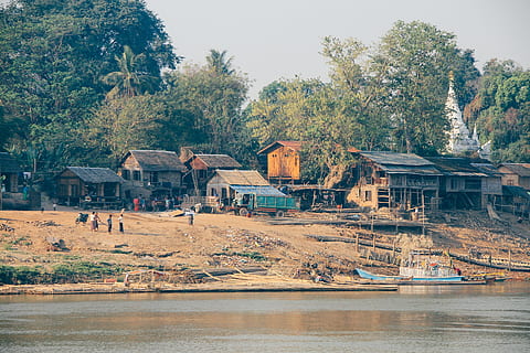 people standing near house, body of water near house at daytime HD wallpaper
