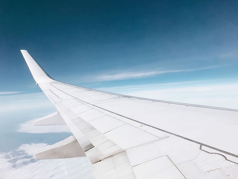 white airplane flying over white clouds, left passenger plane wing during daytime HD wallpaper