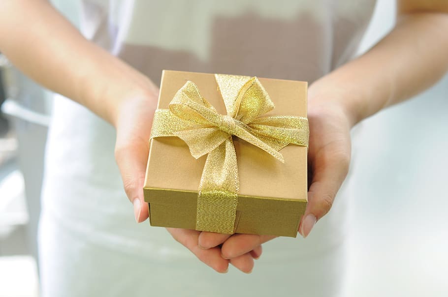 person holding gold box with ribbon, Gifts, Packaging, packaging box