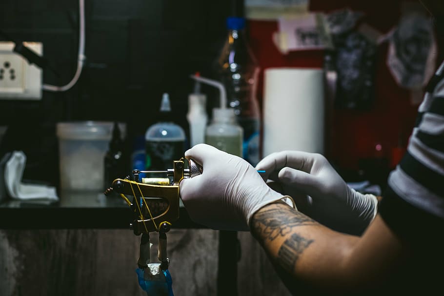 A Tattoo Artist Using a Tattoo Machine · Free Stock Photo