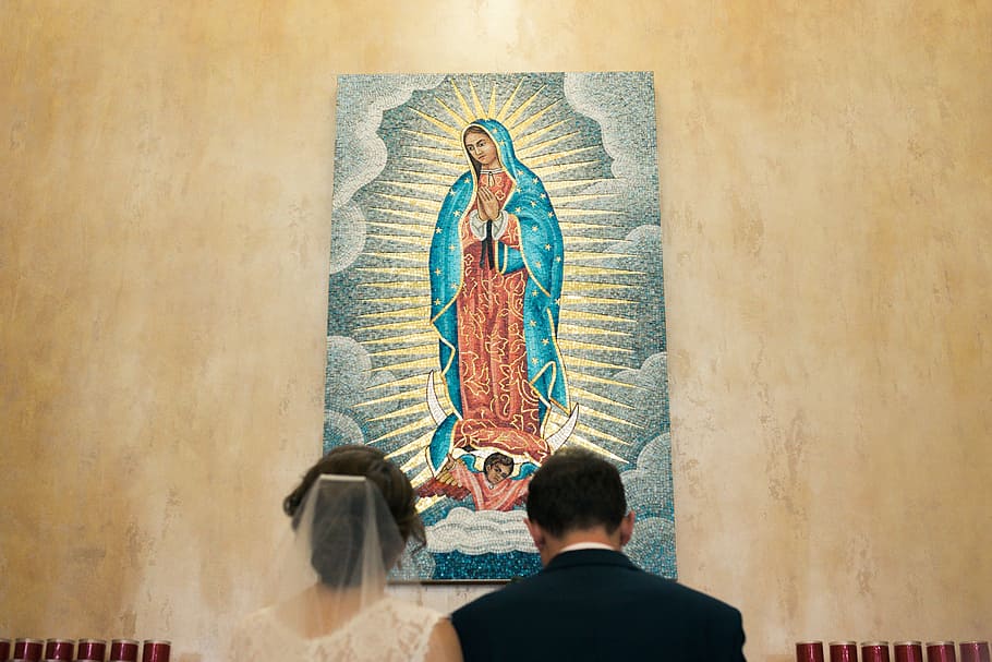 painting of Our Lady of Guadalupe, wedded couple kneeling in front of Our Lady of Guadalupe poster