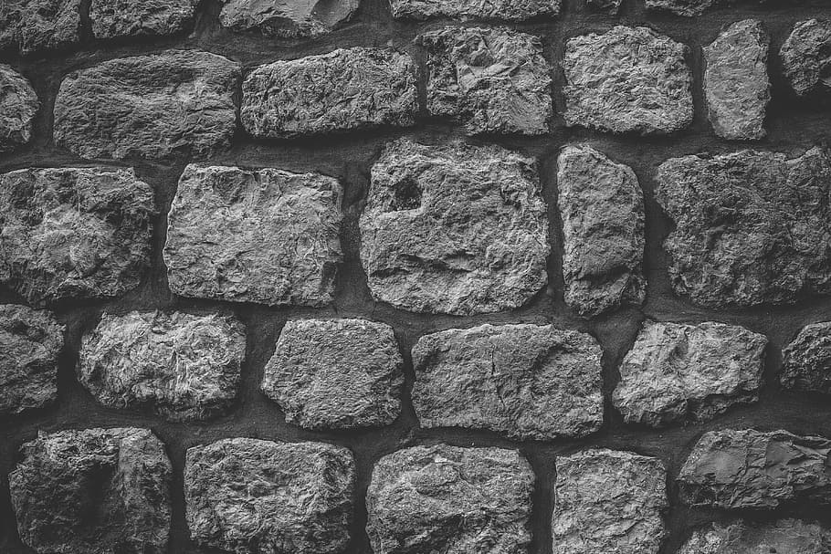 Black and white image of a textured stone wall, textures, backgrounds