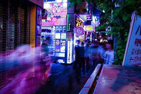 time lapse photo of people walking taken at nighttime, people in clothing on motion on pathway between buildings during nighttime HD wallpaper