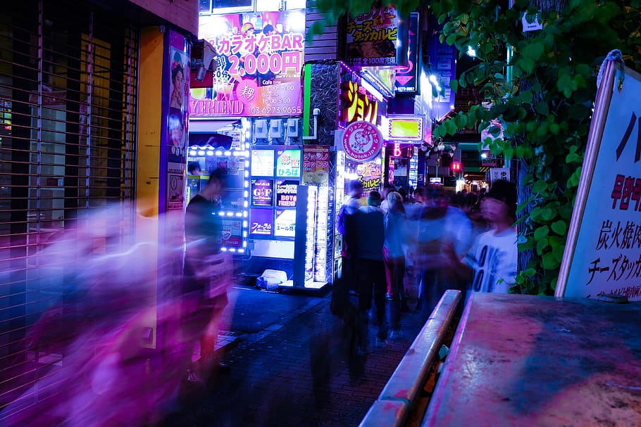 time lapse photo of people walking taken at nighttime, people in clothing on motion on pathway between buildings during nighttime HD wallpaper